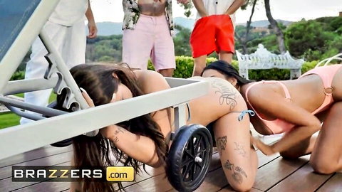 Two curvy tattooed brunettes in bikinis bending over poolside showing big asses to guys