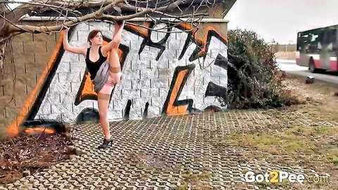 Kinky amateur pulls up leg to pee outdoors by graffiti wall
