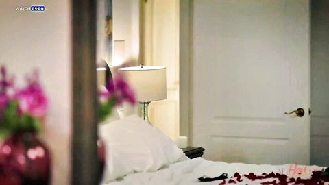 Romantic bedroom with red rose petals scattered on white sheets, soft lamp light and pink flowers for steamy sex setup