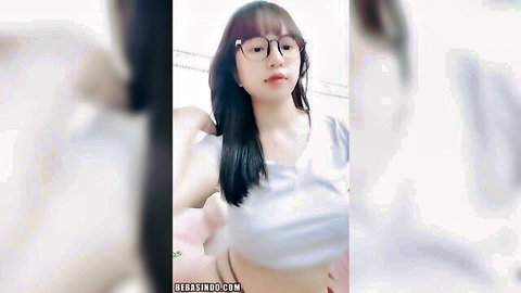 Cute Indonesian Asian girl with glasses lifts tight white shirt teasing underboob and perky tits