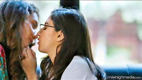 Two young brunette lesbians passionately kissing with tongue in car backseat