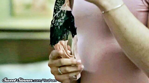 Fair-skinned beauty playfully grips thick black dildo with both hands smiling seductively
