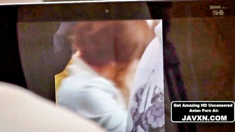 Busty Japanese woman with massive tits bursting from unbuttoned white blouse looking back seductively