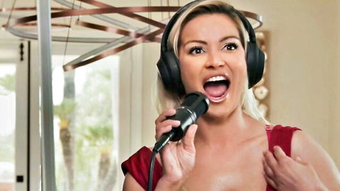 Cherry Kiss blonde model singing passionately in red dress with headphones