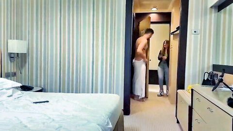 Nude muscular man in towel chats with casual clothed neighbor woman at door