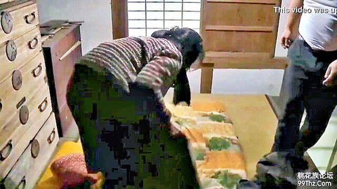 Asian wife bending over bed as friend stands behind in suggestive pose