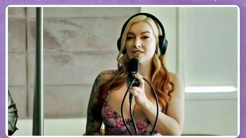 Tattooed blonde in pink lingerie speaks into mic with headphones