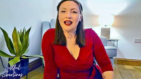 Seductive brunette MILF in red wrap dress with deep cleavage smiling