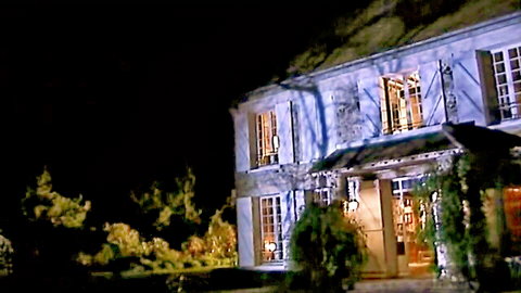Elegant nighttime mansion exterior with warm glowing windows, luxurious setting