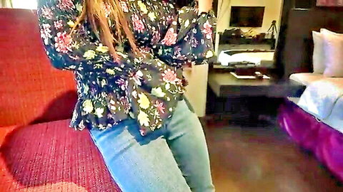 Asian woman in floral blouse and jeans posing seductively for CFNM video