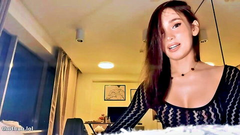Ellie Leen teasing in low-cut black mesh top, deep cleavage cam show