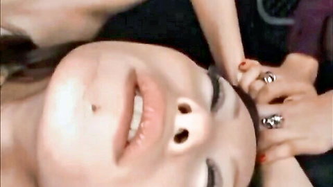 Upside-down Asian beauty's open mouth face gripped by ringed hands in intense rough oral