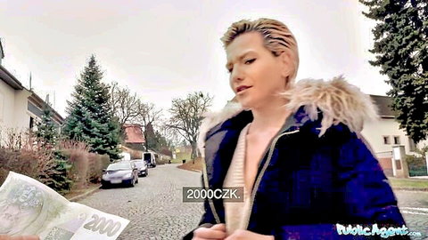 Stunning blonde MILF in fur-trimmed coat flashes cleavage outdoors holding cash