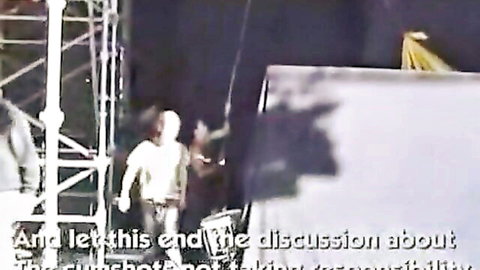 Blurry stage with clothed man walking amid scaffolding and spotlights during performance