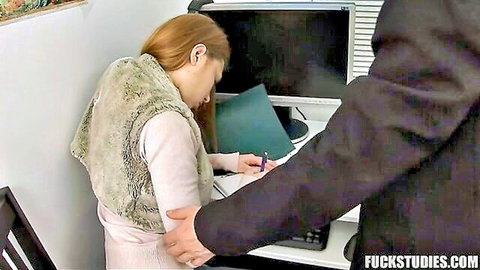 Young redhead student in pink top touched by suited man at office desk