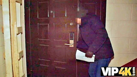 Gloved burglar in purple jacket unlocking electronic door lock in beige hallway