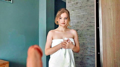 Young blonde teen in white towel clutching it over tits smiling with thumb teasing foreground