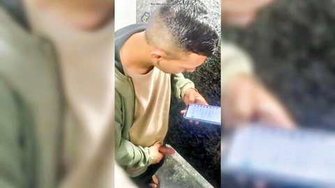 Blurry amateur clip of man checking phone while possibly peeing outdoors