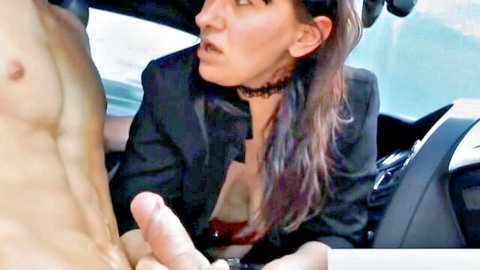 Mature woman in blazer strokes muscular man's cock in car