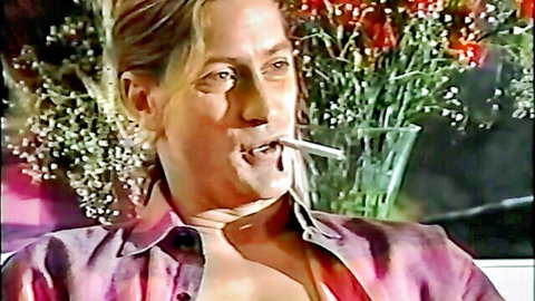 Vintage blonde seductress smoking in open shirt, Eyewitness Nudes 1990