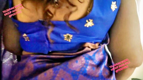 Indian curly-haired MILF in embroidered blue blouse and purple saree, teasing cleavage