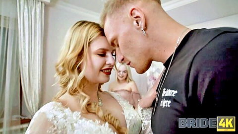 Blonde bride in wedding dress kisses groom as topless friend watches threesome setup