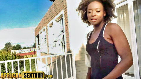 Ebony real estate agent smiling in tight tank top and skirt outdoors