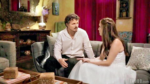 Cadence Lux in white wedding dress talking intimately to man on couch