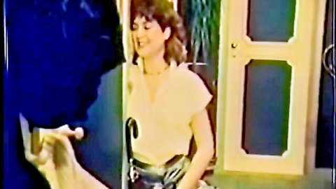 Vintage porn thumbnail: Smiling brunette in yellow top and black skirt teases with male hand near her