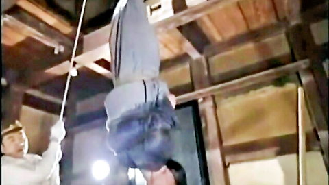 Vintage Asian BDSM scene of bound woman hanging upside down