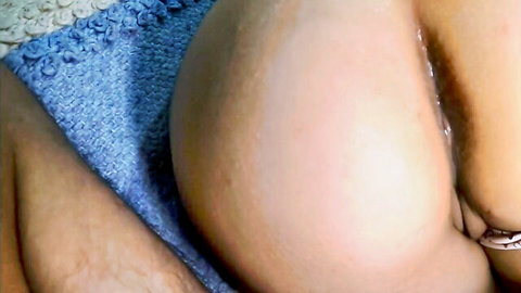 Close-up of curvy woman's exposed ass and wet pussy in blue panties