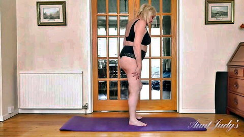 Auntie Amy in black lingerie bending over erotically on yoga mat