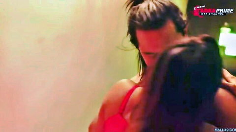 Muscular man hugs busty Indian MILF from behind kissing her neck in red bra
