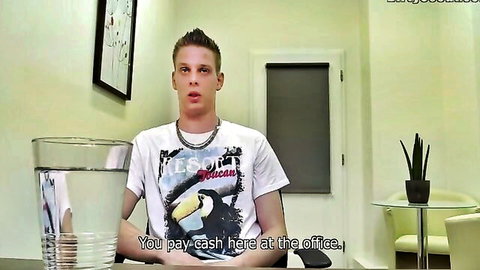 Surprised young man in office wearing 'pay cash here' t-shirt holding water glass, no nudity visible