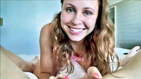 Stella Barey smiling seductively on bed in pink lingerie