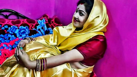 Seductive Indian housewife in yellow saree smiling with bangles and midriff exposed