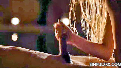 Blonde with long hair sensually gripping thick cock in dim steamy setting