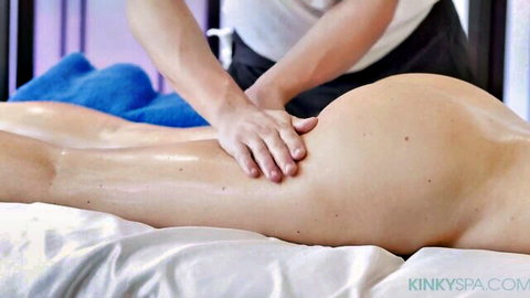 Masseur massages oiled big bare ass of nude curvy woman lying on massage table
