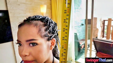 Petite Thai teen with braids posing by height measure showing tiny stature