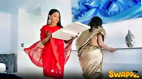 Two busty Indian MILFs in sheer sarees, one bending over shelf exposing backless blouse while other holds tray