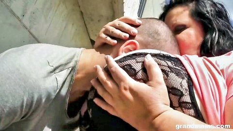Granny grabs bald young man's head pulling it into her lace bra cleavage and big tits
