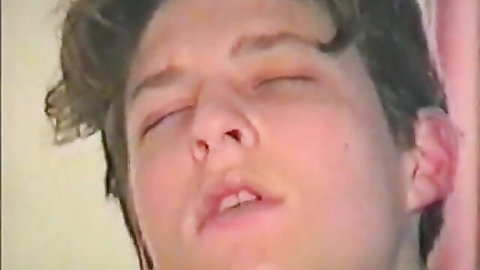 Close-up of young man with curly dark hair, eyes closed in ecstasy