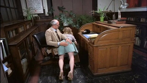 Older man groping young blonde's exposed ass in short skirt over desk