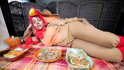 Sexy ebony BBW in tight turkey costume lounges on Thanksgiving feast table teasing curves and big ass