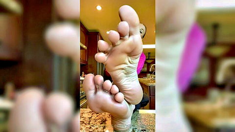 Close-up of sweaty bare Asian feet soles, toes spread wide