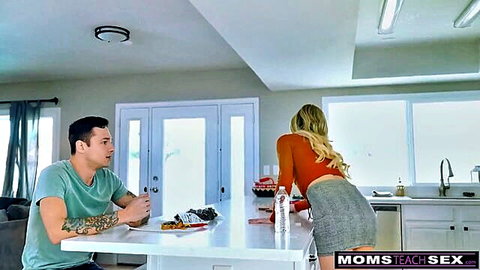 Blonde milf bends over in short skirt, teasing guy at table