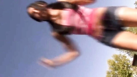 Amia Miley in pink tank top and denim shorts, dynamic jump pose