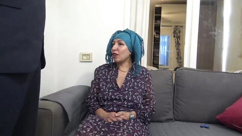 Souzan Halabi in purple dress and blue hijab, teasing with suited man
