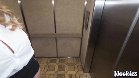 Blonde MILF Misty Caitlin in seductive elevator pose, white blouse and black skirt