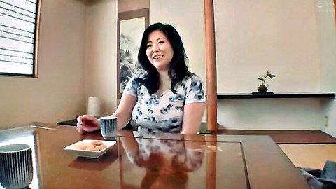 Busty Asian stepmom smiling seductively in floral blouse